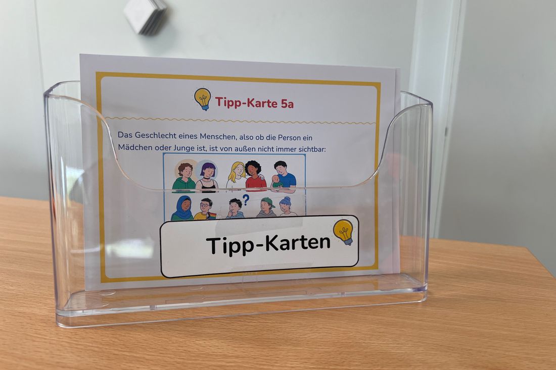 Aufsteller mit Tipp-Karten auf einem Tisch im Klassenraum.